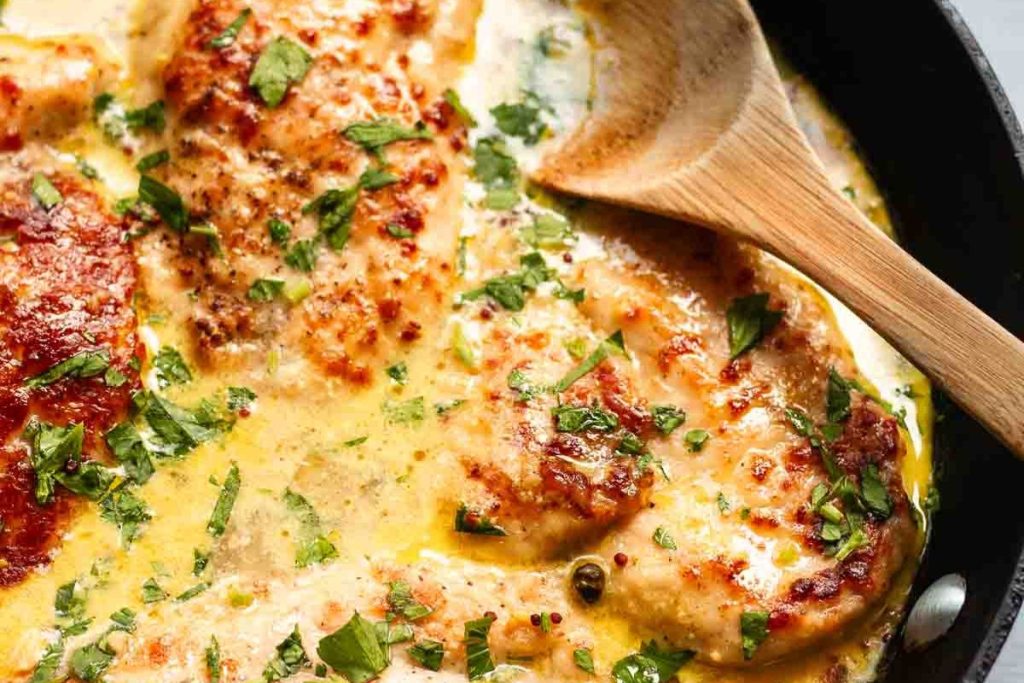 Chicken in parmesan sauce in a pan.