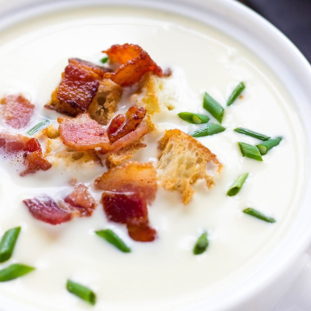 Parmesan soup in a white bowl.